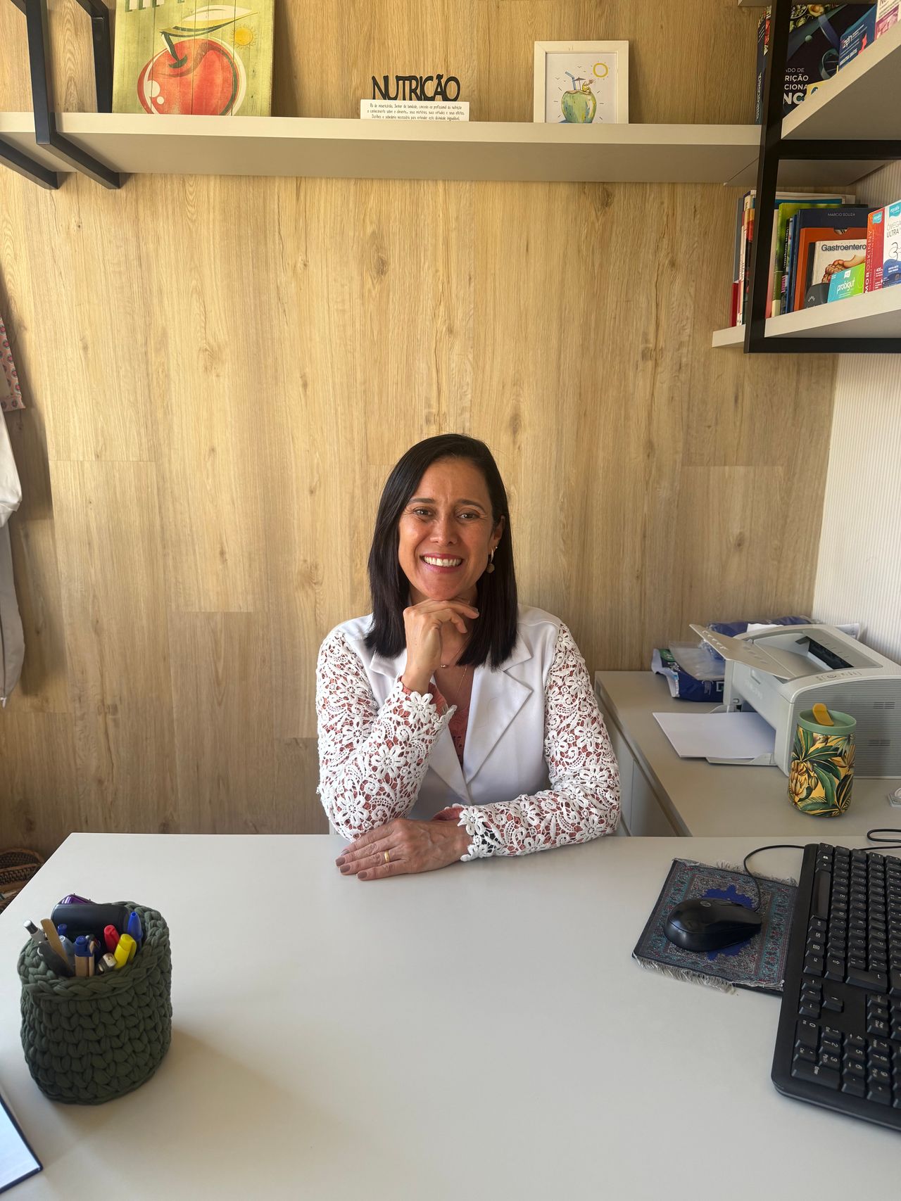 Christiana em seu consultório em Icaraí, com livros de nutrição ao fundo